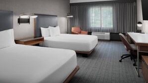 Ein Hotelzimmer mit zwei Betten, einem Schreibtisch, einem Stuhl, einer Lampe und einem großen Fenster mit Vorhängen.