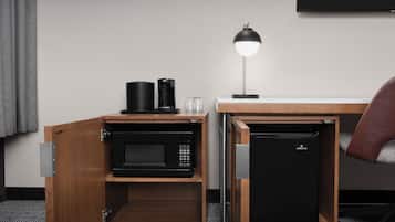 A compact kitchenette with a microwave, coffee maker, and mini-fridge.