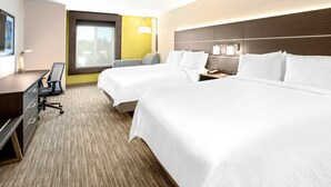 Quarto de hotel com duas camas, uma escrivaninha e uma cadeira.