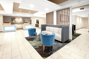 Un hall de hotel con mostrador de recepción, una zona de estar y una kitchenette al fondo.