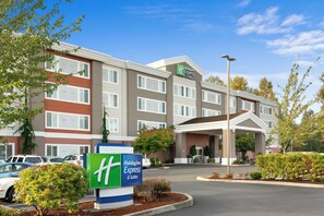 Un hôtel Holiday Inn Express & Suites doté d’une façade moderne, de nombreuses fenêtres et d’un hall d’entrée bien entretenu.
