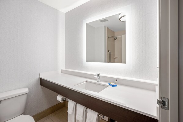 A modern bathroom with a white sink, a mirror, and a shower.