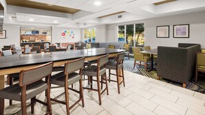 Un espace repas moderne doté d’une longue table conviviale, de cabines individuelles et d’un bar pour le petit-déjeuner.