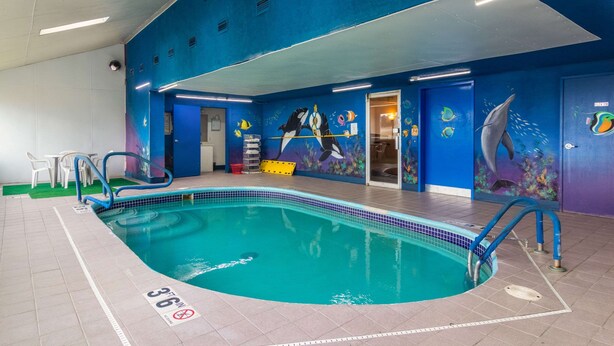 Ein Hallenbad mit blauen Wänden, einem gefliesten Boden und einem Sprungverbotsschild.