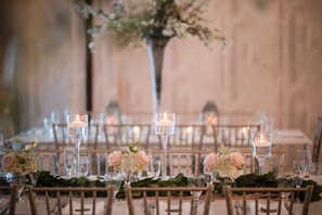 A table set for a formal event with candles, glassware, and floral centerpieces. - Hilton Garden Inn Hamilton (Robbinsville)