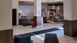A modern hotel lobby with a reception desk, seating area, and a food bar. - Hilton Garden Inn Mankato Downtown (Mankato)
