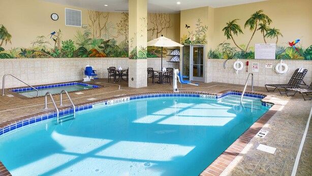 An indoor swimming pool with a tiled edge, a lifeguard chair, and a pool rule sign. - Hilton Garden Inn Mankato Downtown (Mankato)