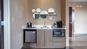A modern kitchen with a double sink, a built-in microwave, and a compact refrigerator. - Hilton Garden Inn Mankato Downtown (Mankato)
