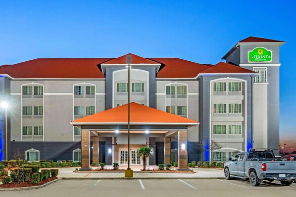 A hotel with a red roof, a covered entrance, and a sign for La Quinta Inn & Suites.
