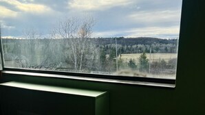 A room with a large window overlooking a landscape. - Lively Inn & Suites (Sudbury)