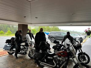 A covered parking area with motorcycles and cars. - Lively Inn & Suites (Sudbury)