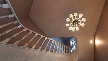 A staircase with a white balustrade and a chandelier with multiple light fixtures.