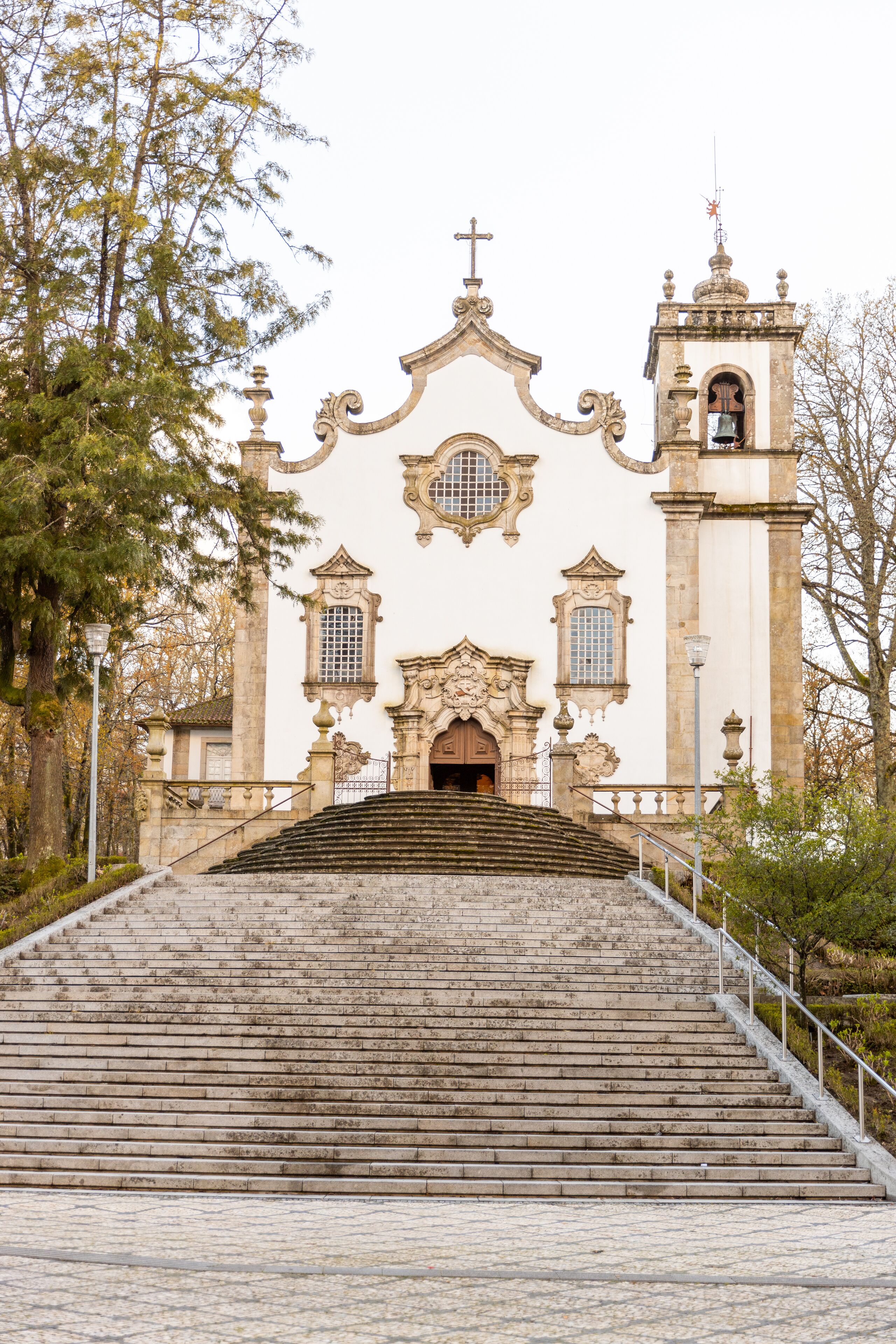 A church with a bell tower and a staircase leading to the entrance.
