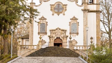 A church with a bell tower and a staircase leading to the entrance.