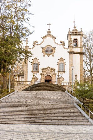 Una iglesia con un campanario y una escalera que conduce a la entrada.