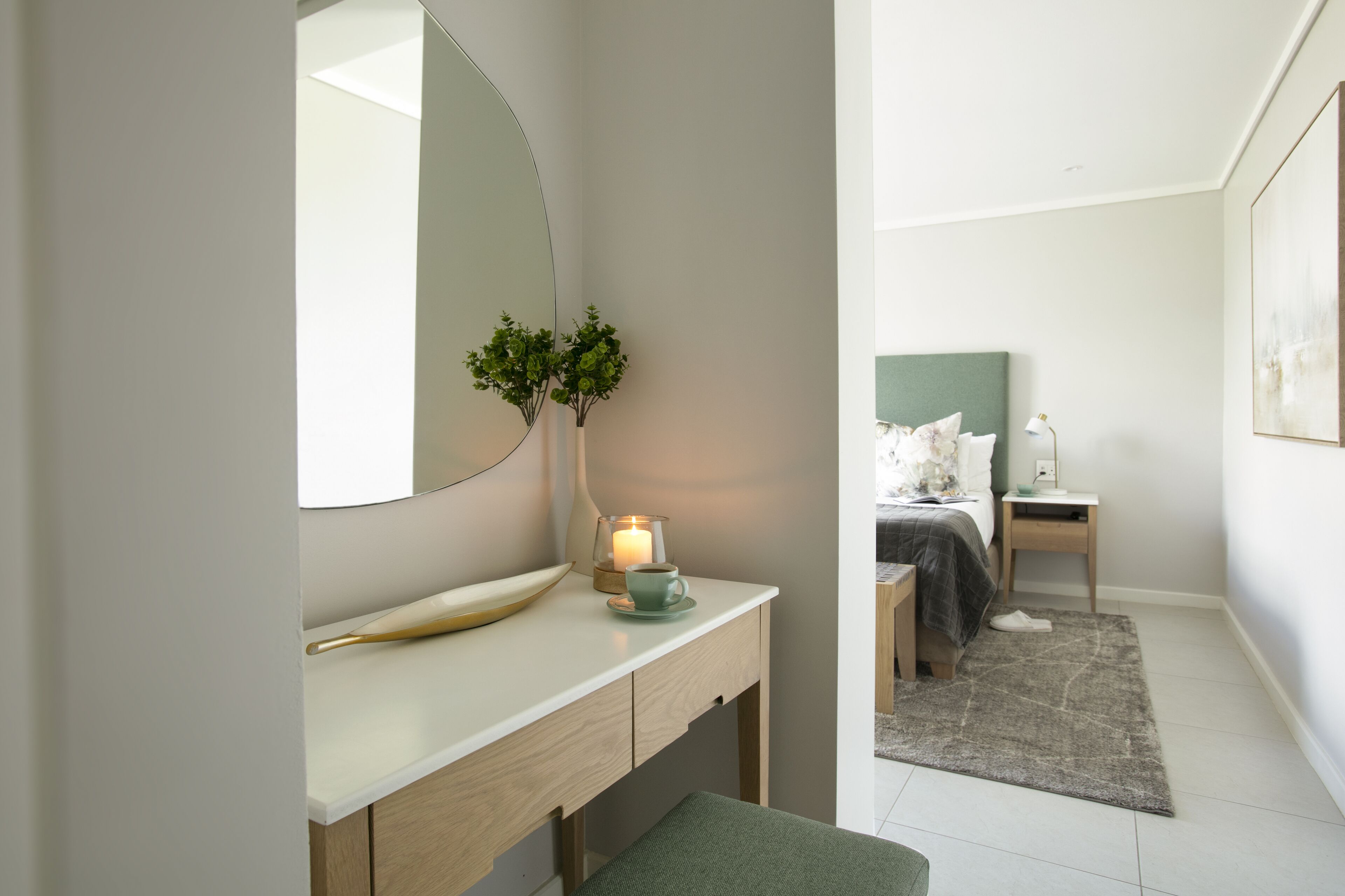 Een moderne slaapkamer met een bed, nachtkastje en een nachttafeltje.