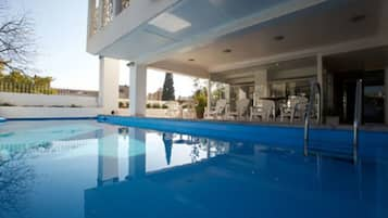 Una piscina al aire libre, sombrillas, guardavidas en la propiedad