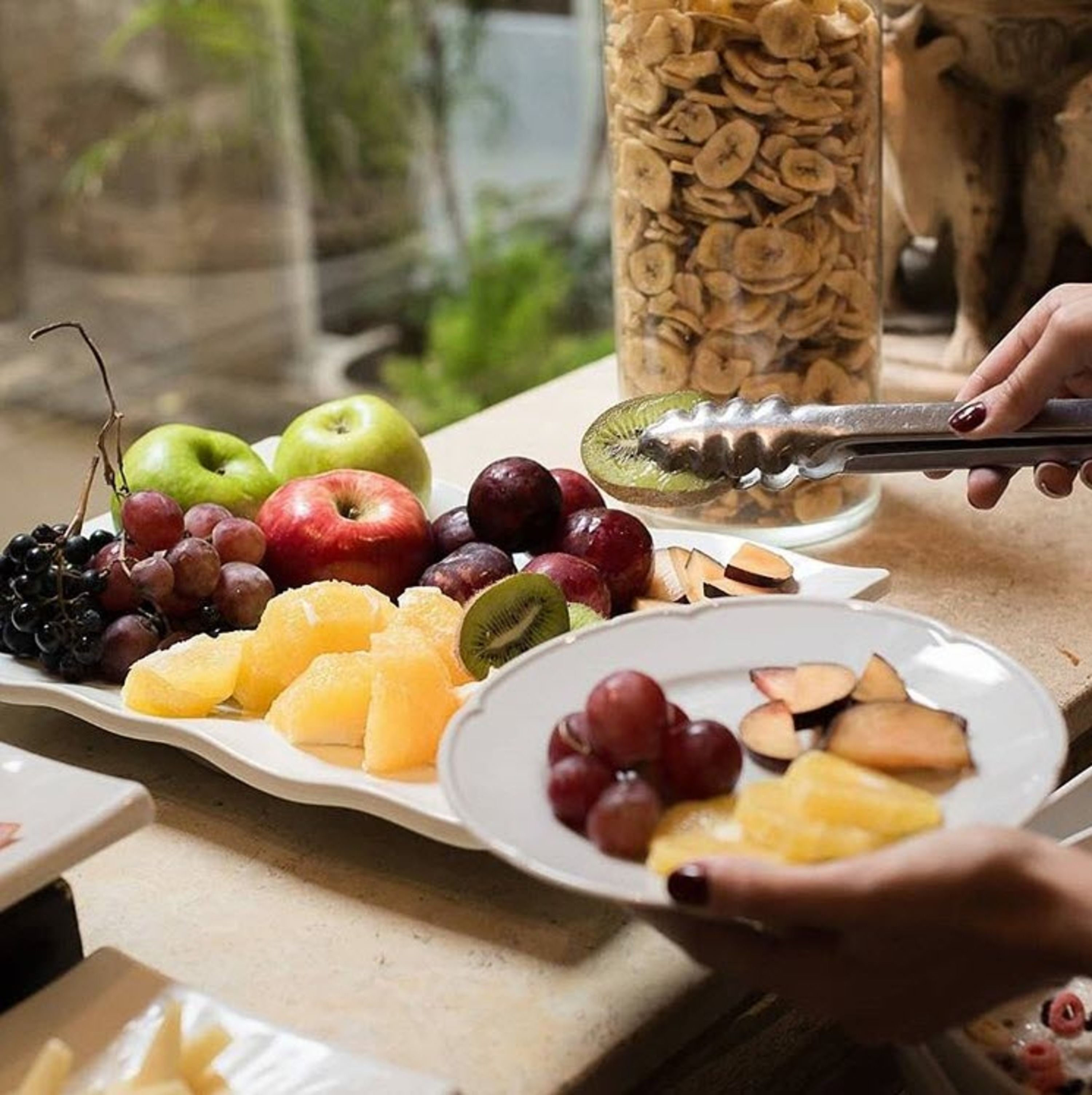 Een fruitschaal met appels, druiven, kiwi en ander fruit.