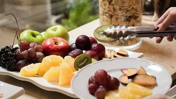 A fruit platter with apples, grapes, kiwi, and other fruits.