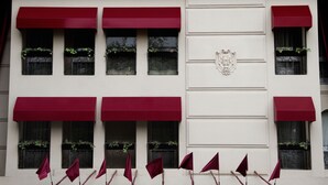 The exterior of Huentala Hotel with red awnings, decorative columns, and a crest emblem.