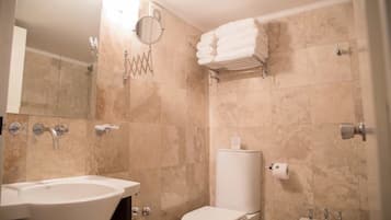 A bathroom with a freestanding bathtub, a toilet, a sink, and a towel rack.