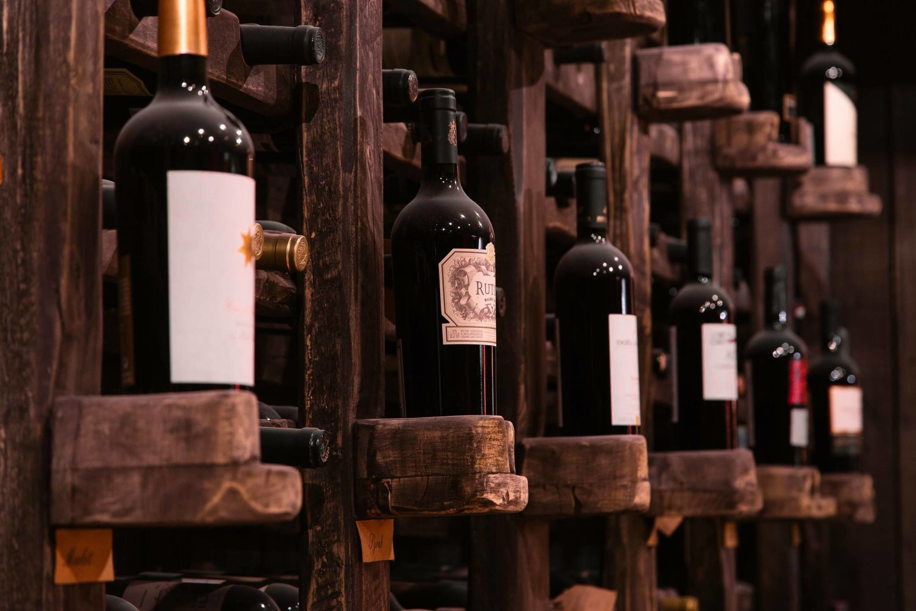 A wine cellar with wooden racks holding bottles of wine.