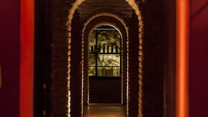 A corridor with arched brick walls and a window at the end. - Huentala Hotel (Mendoza)