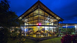 A modern building with a glass facade, multiple dining areas, and a visible entrance.