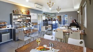 A modern restaurant with a bar area, dining tables, and chairs. - Comfort Inn & Suites Burwood (Burwood)