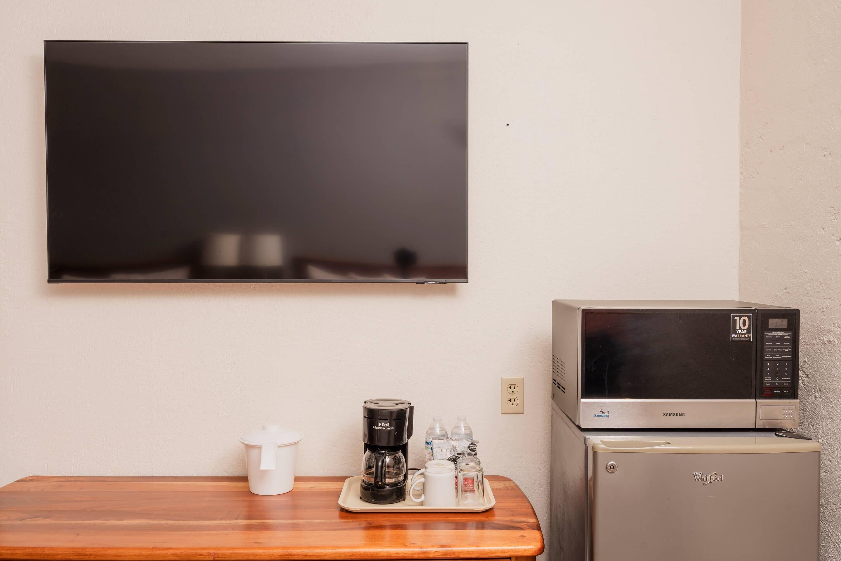 Una kitchenette equipada con microondas, cafetera y un refrigerador pequeño.