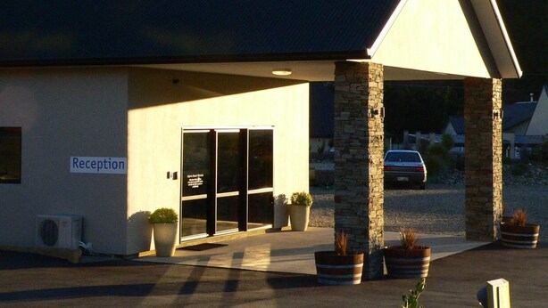 A building with a reception area, large windows, and potted plants. - Alpine Resort Wanaka – A THC Hotels and Resorts (Wanaka)