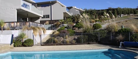 Una piscina al aire libre, tumbonas