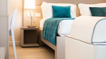Una habitación de hotel moderna con una cama, mesita de noche, lámpara y una silla.
