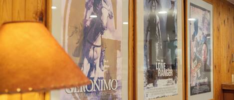 Framed movie posters on a wall with a lamp in the foreground.