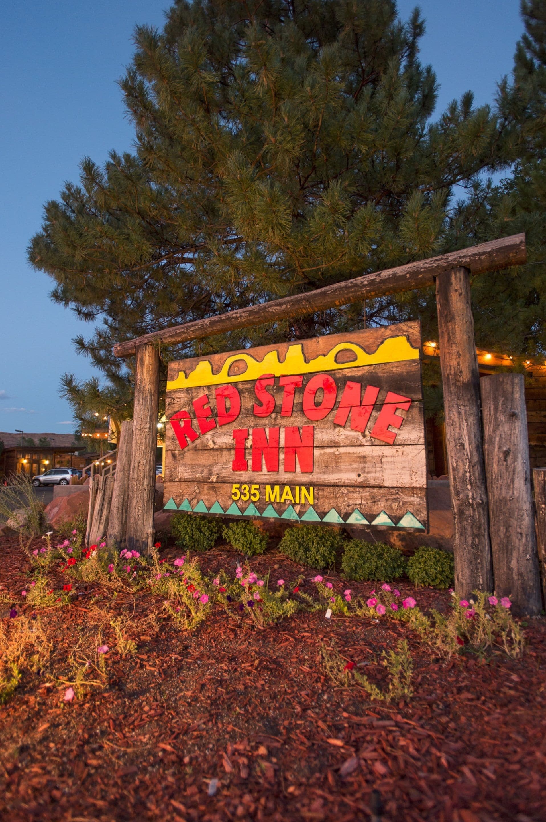 A wooden sign for Red Stone Inn with a mountain silhouette and the address 535 Main.