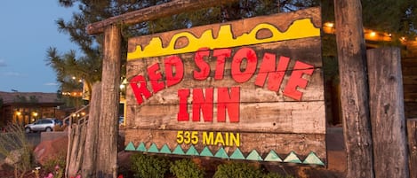 A wooden sign for Red Stone Inn with a mountain silhouette and the address 535 Main.
