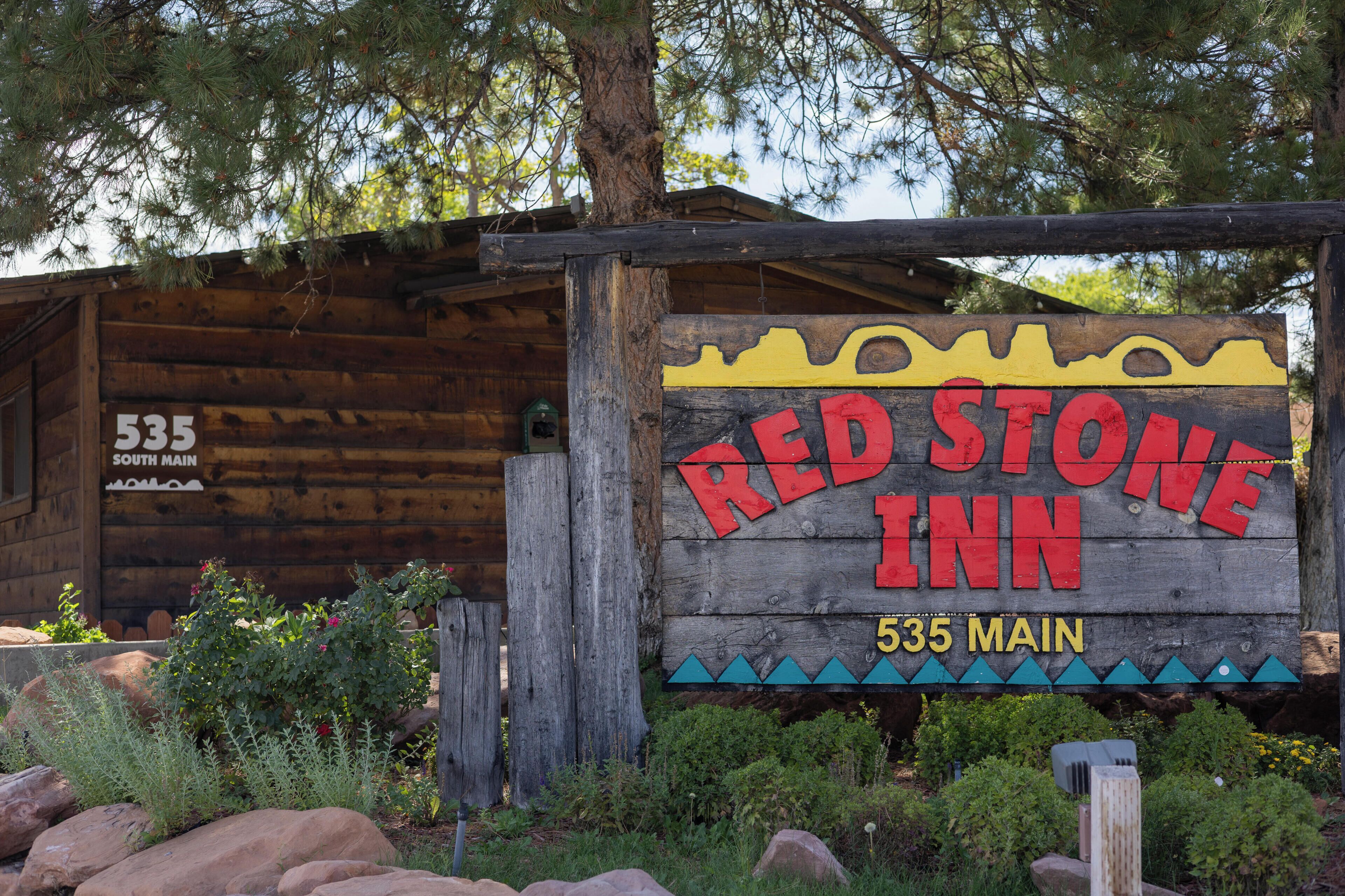 Un letrero de madera rústico del Red Stone Inn con el número '535' indicando la dirección.