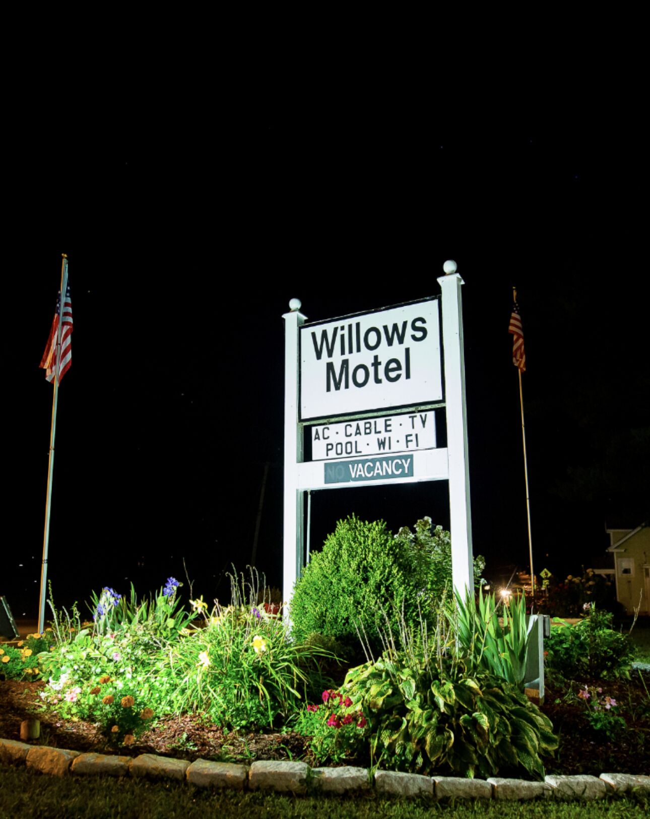 A Willows Motel sign with amenities listed: AC, cable TV, pool, Wi-Fi, and no vacancy.