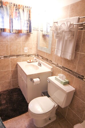 A bathroom with a toilet, sink, and towel rack.