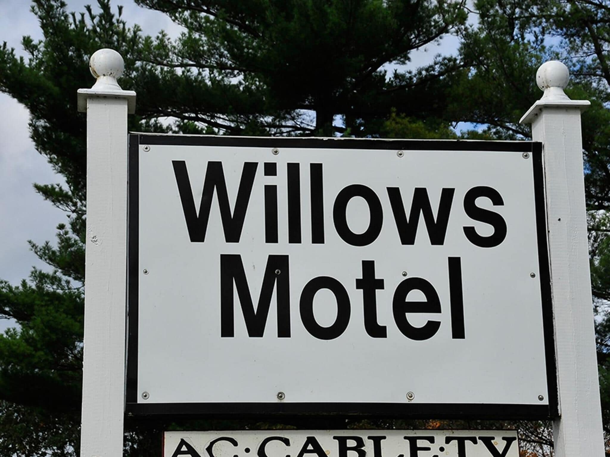 A sign for Willows Motel with a simple, clear font on a white background.