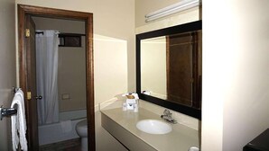 A bathroom with a sink, mirror, and toilet. - Travelodge by Wyndham Concord (Concord)