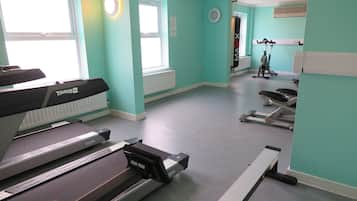 A gym with treadmills, a stationary bike, and a punching bag.