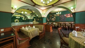 Un restaurante con cabinas de madera, mesas con manteles a cuadros y un candelabro.