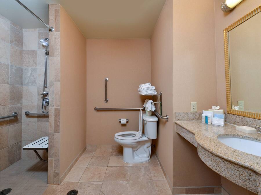 A bathroom with a shower, toilet, and sink.