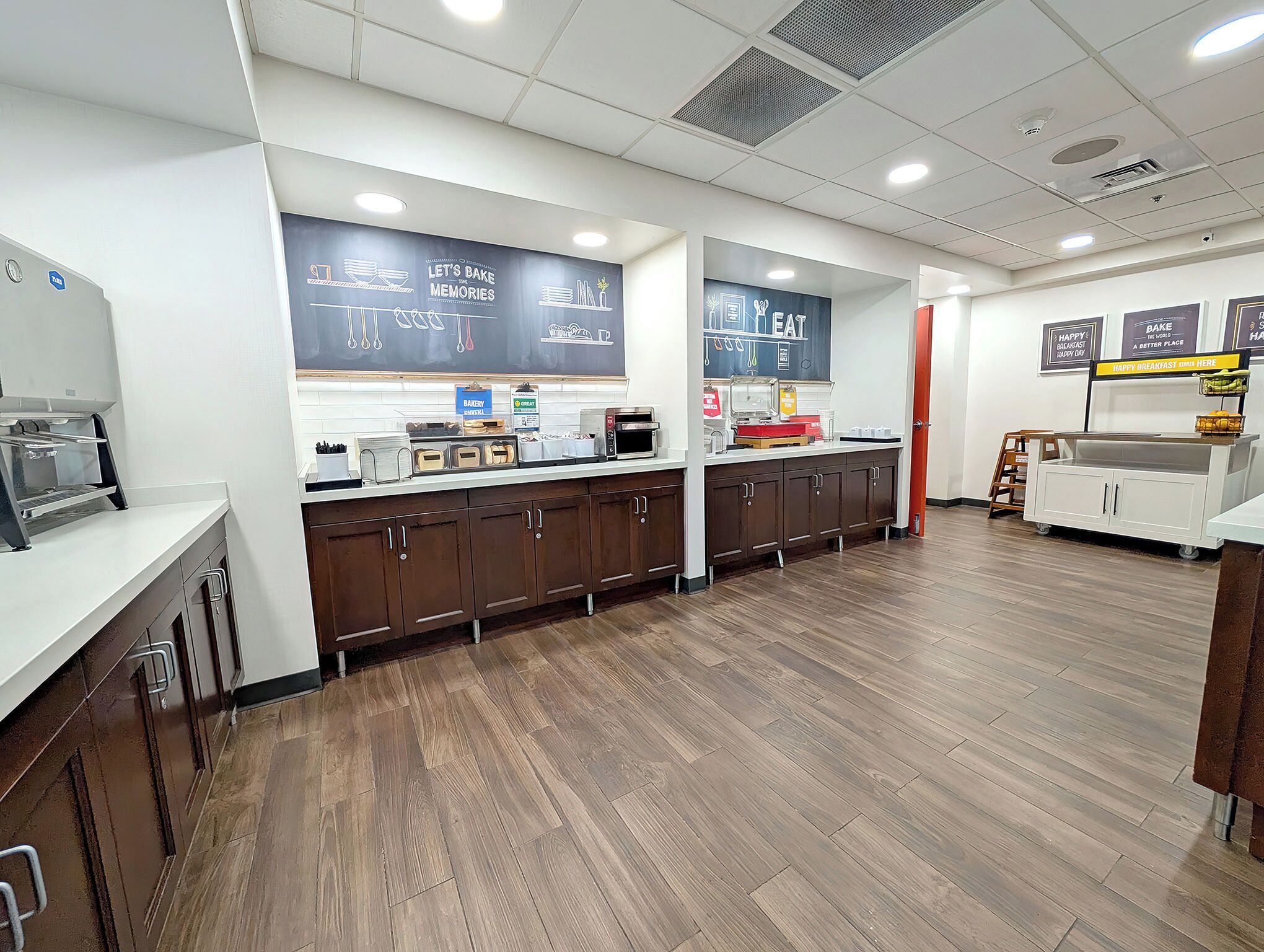 Een bakkerij toonbank met een krijtbord menu, een koffieapparaat en een magnetron.
