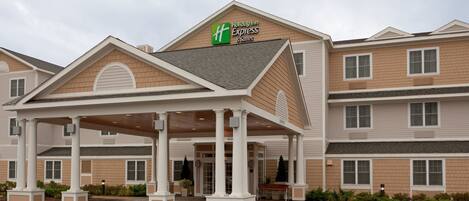 A Holiday Inn Express & Suites with a covered entrance and a brick facade.