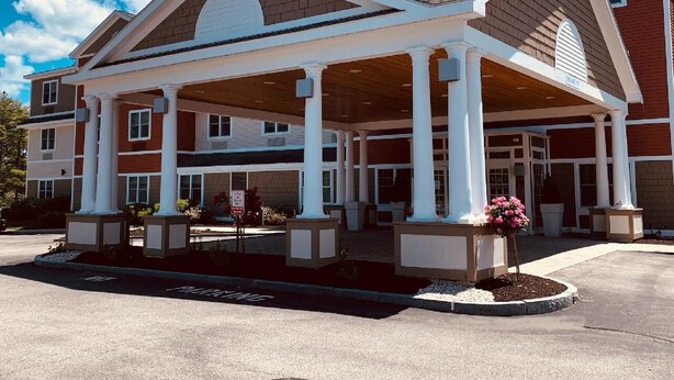 A Holiday Inn Express building with a covered outdoor area, columns, and a landscaped entrance. - Holiday Inn Express & Suites Rochester by IHG (Rochester)