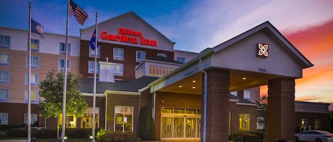 A Hilton Garden Inn with a clear entrance, flag display, and a sign indicating the year 1998.