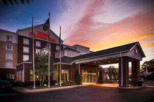 Un Hilton Garden Inn con cielo despejado y atardecer.