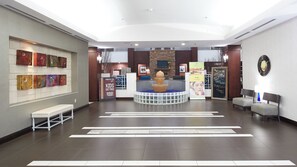 A lobby with a reception desk, seating area, and artwork on the walls. - Holiday Inn & Suites Stockbridge/Atlanta I-75 by IHG (Stockbridge)